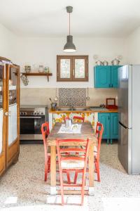 una cocina con armarios azules y una mesa de madera con sillas. en Cantunera Barbára, en Torre Nubia