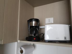 una macchinetta del caffè su una mensola accanto a una stampante di Tranquilo y Acogedor departamento en Con Con a Concón