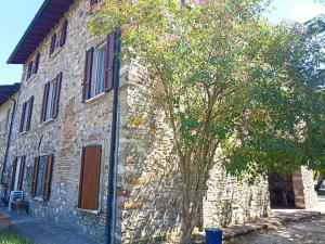 a stone building with a tree in front of it at Cà Vittoria in Desenzano del Garda