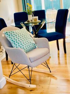 a living room with a chair and a glass table at Tanglewood house Abergavenny with private parking in Abergavenny