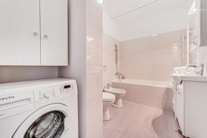 a white bathroom with a washing machine in it at ARI Purple Studio in Arad