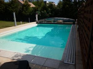 a swimming pool with blue water in a yard at Luxury Villa Heviz in Hévíz