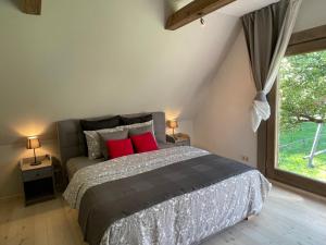 a bedroom with a bed with red pillows and a window at Apartamenti MEKE in Limbaži