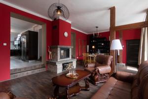 a living room with red walls and a fireplace at Golden Tree Loft in the Heart of Prague in Prague