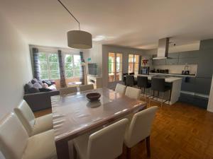 uma cozinha e sala de estar com uma mesa de madeira e cadeiras em T5 Disney Paris/Val d’Europe em Serris