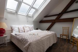 a bedroom with a bed in a room with windows at Golden Tree Loft in the Heart of Prague in Prague