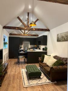 a living room with a couch and a kitchen at Springfield Lodge - Adorable New Forest 1-bedroom guest house in Ringwood