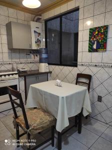 a kitchen with a table and two chairs and a table and a window at Departamentos Vacacionales en el centro de Tarija in Tarija