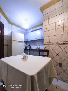 a kitchen with a table with a white table cloth on it at Departamentos Vacacionales en el centro de Tarija in Tarija