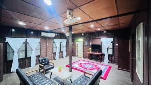 a room with a stage with chairs and a red rug at HERITAGE D'CENANG with Jacuzzi Spa in Pantai Cenang