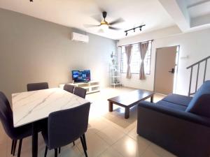 salon ze stołem jadalnym i kanapą w obiekcie ₘₐcₒ ₕₒₘₑ Premium Suite 3R2B CorNer @Mount Austin 【TMN DAYA】 w mieście Johor Bahru