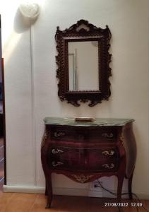 een spiegel aan een muur naast een dressoir bij CasaVacanze Salza nel Borgo in Sutri