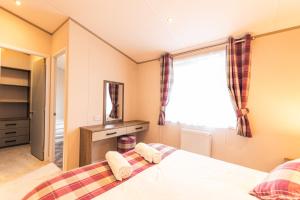 モルトンにあるBella Rose Lodge with Hot Tubのベッドルーム1室(ベッド1台、大きな窓付)