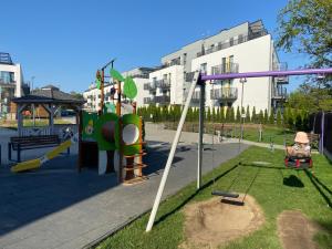 a park with a playground with a swing at Apartamenty Poproszę na Plażę in Jastrzębia Góra