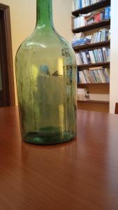 Melizzano的住宿－Casa vacanze ACQUAVIVA，坐在桌子上的一个绿玻璃瓶