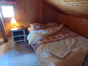 - une chambre avec un lit dans une cabane en bois dans l'établissement Chalet Tyl, vue imprenable sur les Alpes Valaisannes, à Crans-Montana