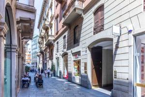 a city street with people sitting in chairs on a sidewalk at VIA DELLA SPIGA N50 - Luxury Loft in the Heart of the Fashion District in Milan