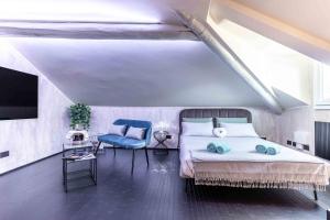 una camera con letto, TV e sedia di VIA DELLA SPIGA N50 - Luxury Loft in the Heart of the Fashion District a Milano