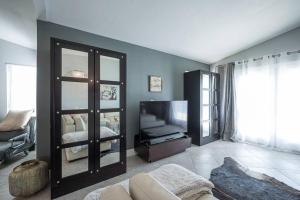 een woonkamer met een grote spiegel en een tv bij Modern Home! Pool & Jacuzzi (30% off for longterm) in Las Vegas