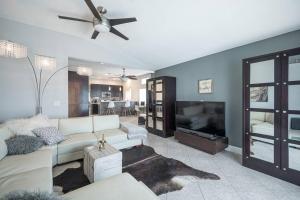 een woonkamer met een witte bank en een plafondventilator bij Modern Home! Pool & Jacuzzi (30% off for longterm) in Las Vegas