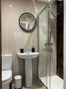 a bathroom with a sink and a glass shower at Springfield Lodge - Adorable New Forest 1-bedroom guest house in Ringwood