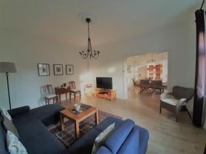 a living room with a blue couch and a table at Ferienwohnung-Stricker-Bad-Sachsa in Bad Sachsa