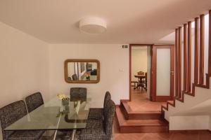 a dining room with a glass table and chairs at Casa Dona Ermelinda - Silêncio - Conforto - Natureza in Outeiro Maior