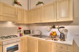 a kitchen with wooden cabinets and a sink at Romance al Colosseo in Rome