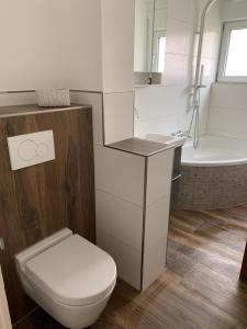 a bathroom with a toilet and a sink and a tub at Helle Wohnung mit Wintergarten, Terrasse und Garten in Bad Liebenzell