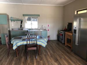 a kitchen with a table with chairs and a refrigerator at Daberas Guest Farm in Augrabies