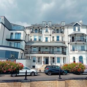 a large white building with cars parked in front of it at Glorious Duplex Holiday Apartment By The Sea in Bognor Regis