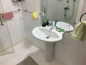 biała łazienka z umywalką i prysznicem w obiekcie Paradise holidays in the tropics w mieście Kottanitivu