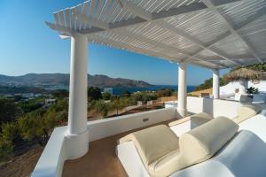 pérgola blanca con sofá y sillas en el balcón en Hidden Oasis Private Villa, en Agia Marina