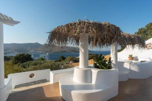 a view of the ocean from a house with a straw umbrella at Hidden Oasis Private Villa in Agia Marina