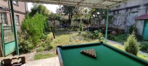 a pool table in a yard with a garden at Guest House Tall Rooms in Zugdidi
