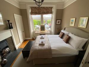 um quarto com uma cama grande e uma lareira em Braid Rd Stunning Villa em Edimburgo