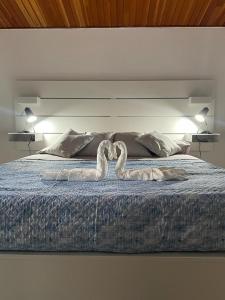 a bed with two swans made to look like hearts at The White Sail - Mondello Apartment with Terrace - casa di vincenzo e andrea in Mondello