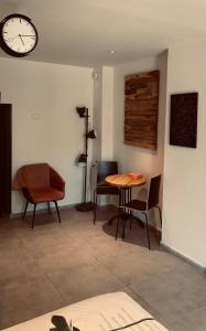 a room with a table and chairs and a clock at La Guta Studio Loft The Renee Suite in Jerusalem