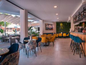 a restaurant with chairs and tables and a bar at INN Mallorca Aparthotel in Magaluf