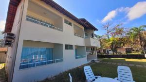 a house with two chairs and a table in the yard at Pousada Areia e Mar in Ubatuba