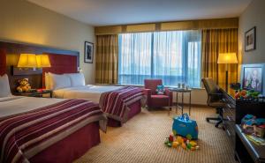 Pillo Hotel & Leisure Club في أشبورني: غرفة فندقية تحتوي على سريرين وكرسي