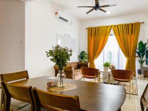 a living room with a wooden table and chairs at Tamu Place 3-Bedroom Serviced Apartment with Pool in Kuala Terengganu
