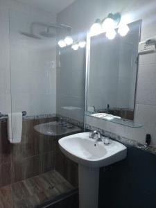 bagno con lavandino e specchio di Hotel Picos Del Sur a El Calafate
