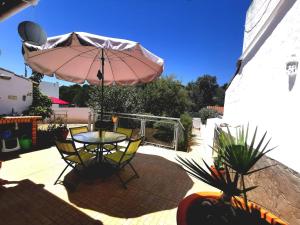 une terrasse avec une table et un parasol dans l'établissement Silves Country Room, à Silves