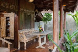 un portico con panchina, tavolo e alcune piante di The Meranggi ad Ubud