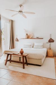 um quarto com uma cama e uma mesa em Casa Stellar - boutique villa with private heated pool and sea view - sustainably solar powered em San Jose de sa Talaia