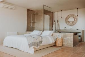 a bedroom with a large bed and a bathroom at Casa Stellar - boutique villa with private heated pool and sea view - sustainably solar powered in Sant Josep de sa Talaia
