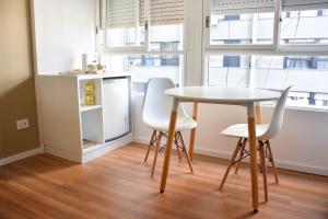einen Tisch und zwei Stühle in einem Zimmer mit Fenstern in der Unterkunft Studio Congreso in Buenos Aires