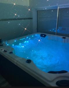 een grote blauwe badkuip met verlichting in de badkamer bij Chez Sophie in Altviller