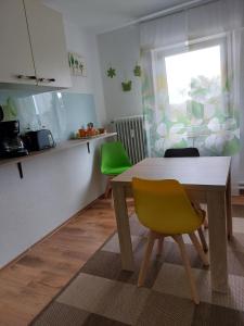 uma cozinha com uma mesa de madeira e uma cadeira amarela em Ferienwohnung Mona Herford em Herford